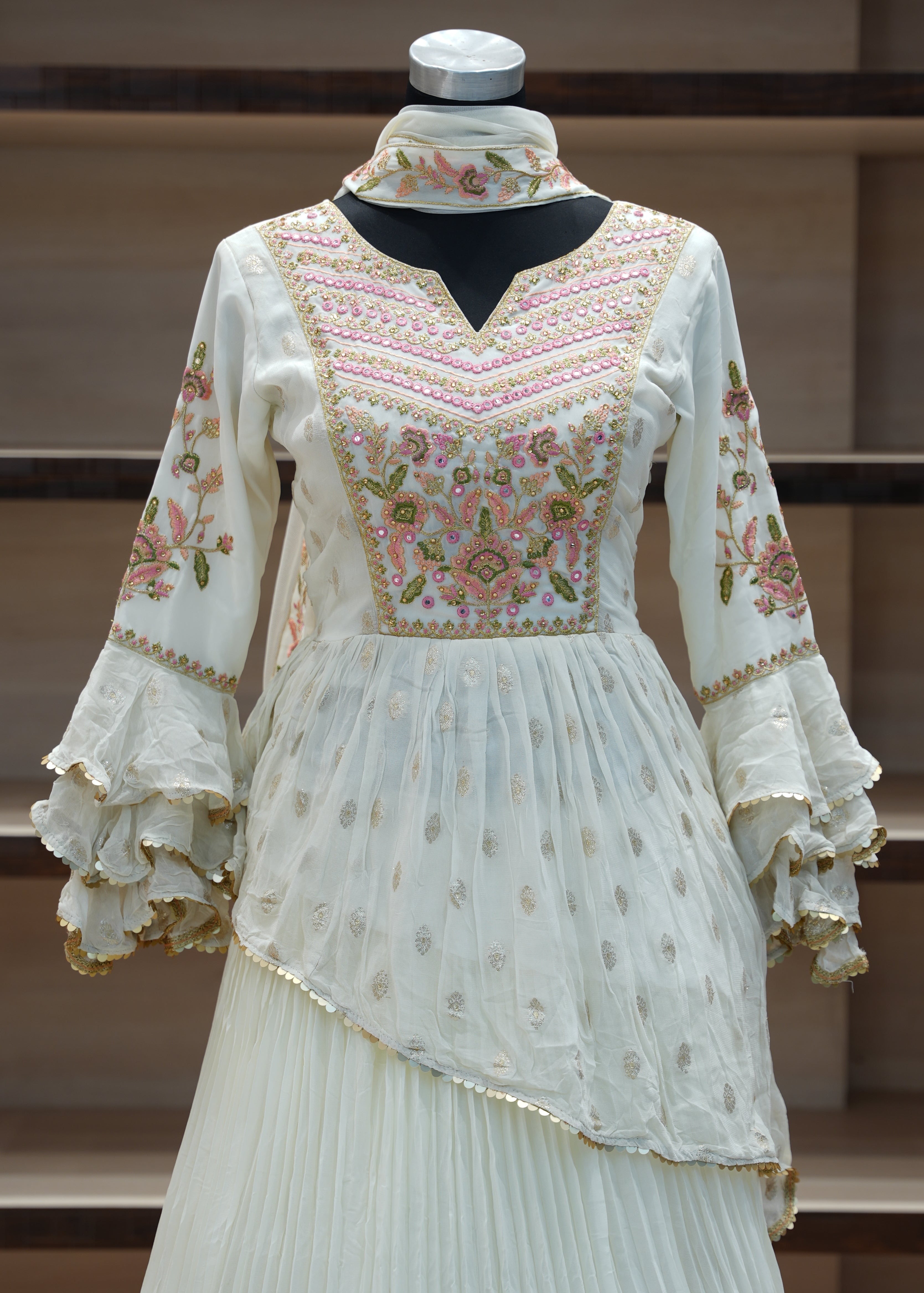 Traditional embroidered dress on a mannequin against a wooden background