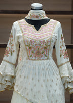 White embroidered dress on a mannequin against a neutral background