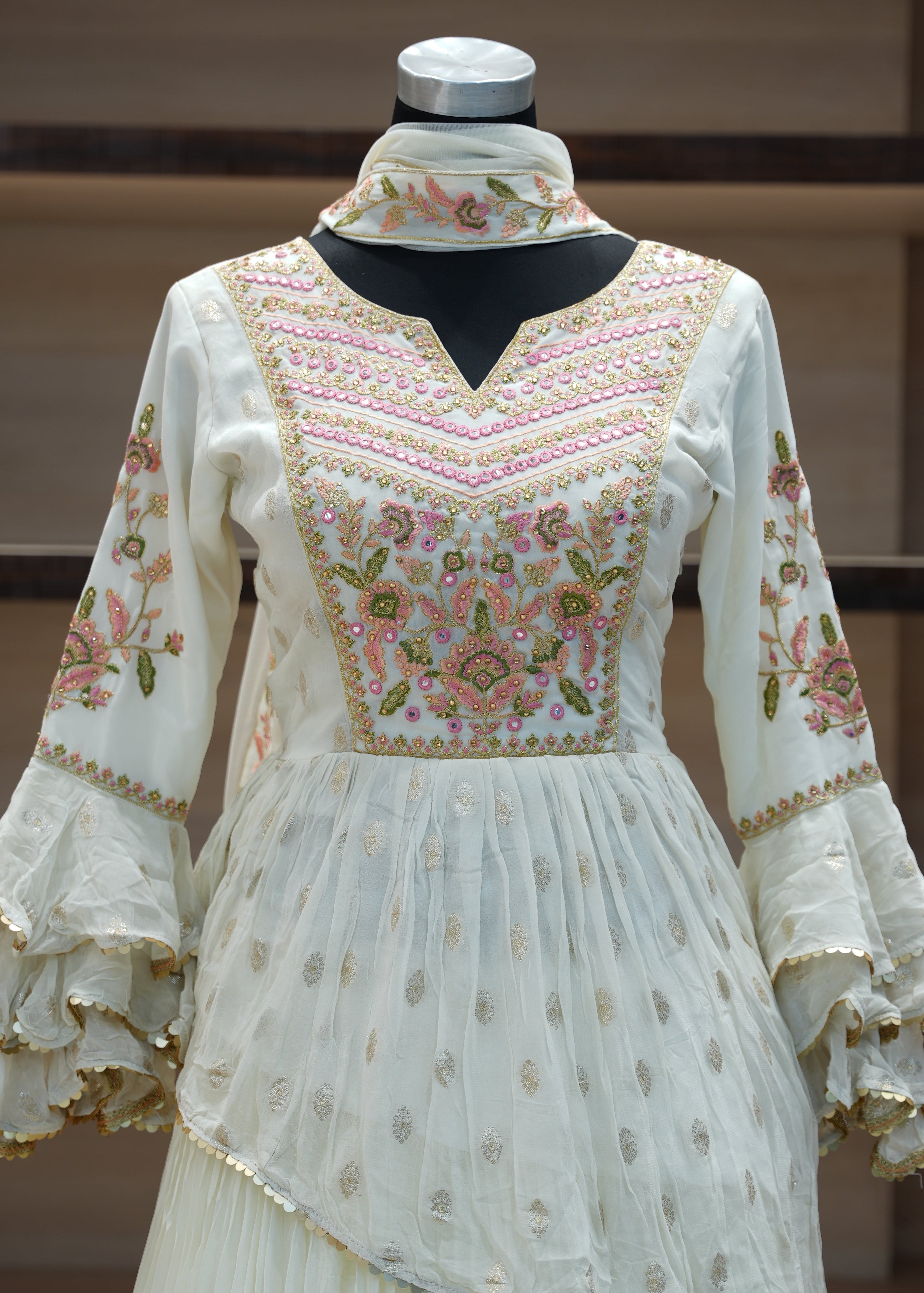 White embroidered dress on a mannequin against a neutral background