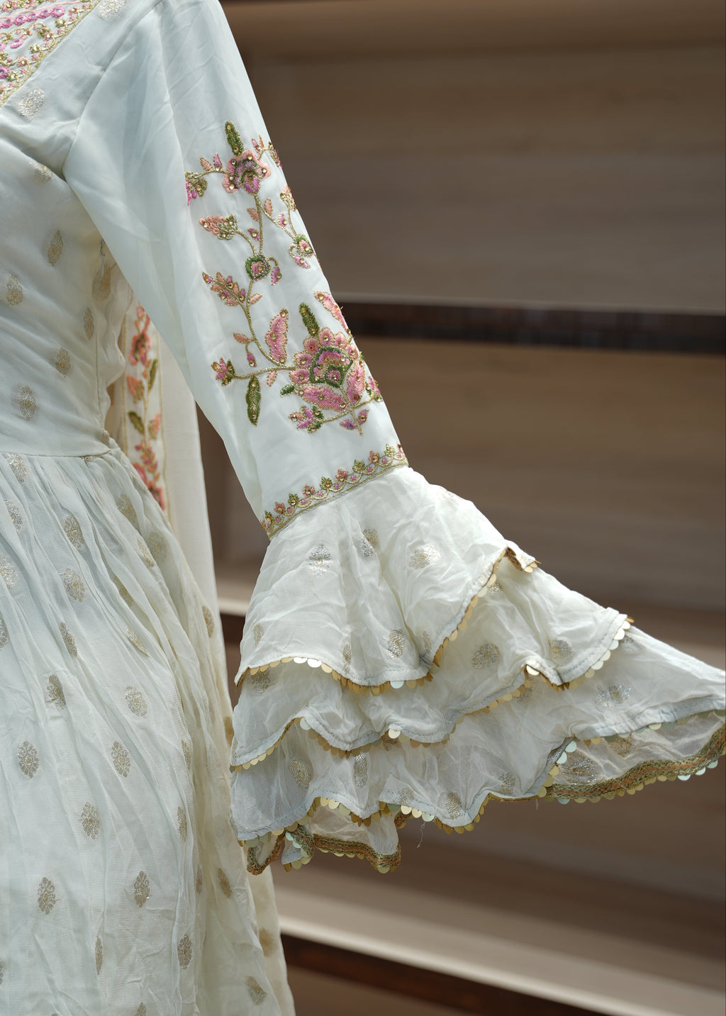 Close-up of a white embroidered fabric with floral patterns on a neutral background