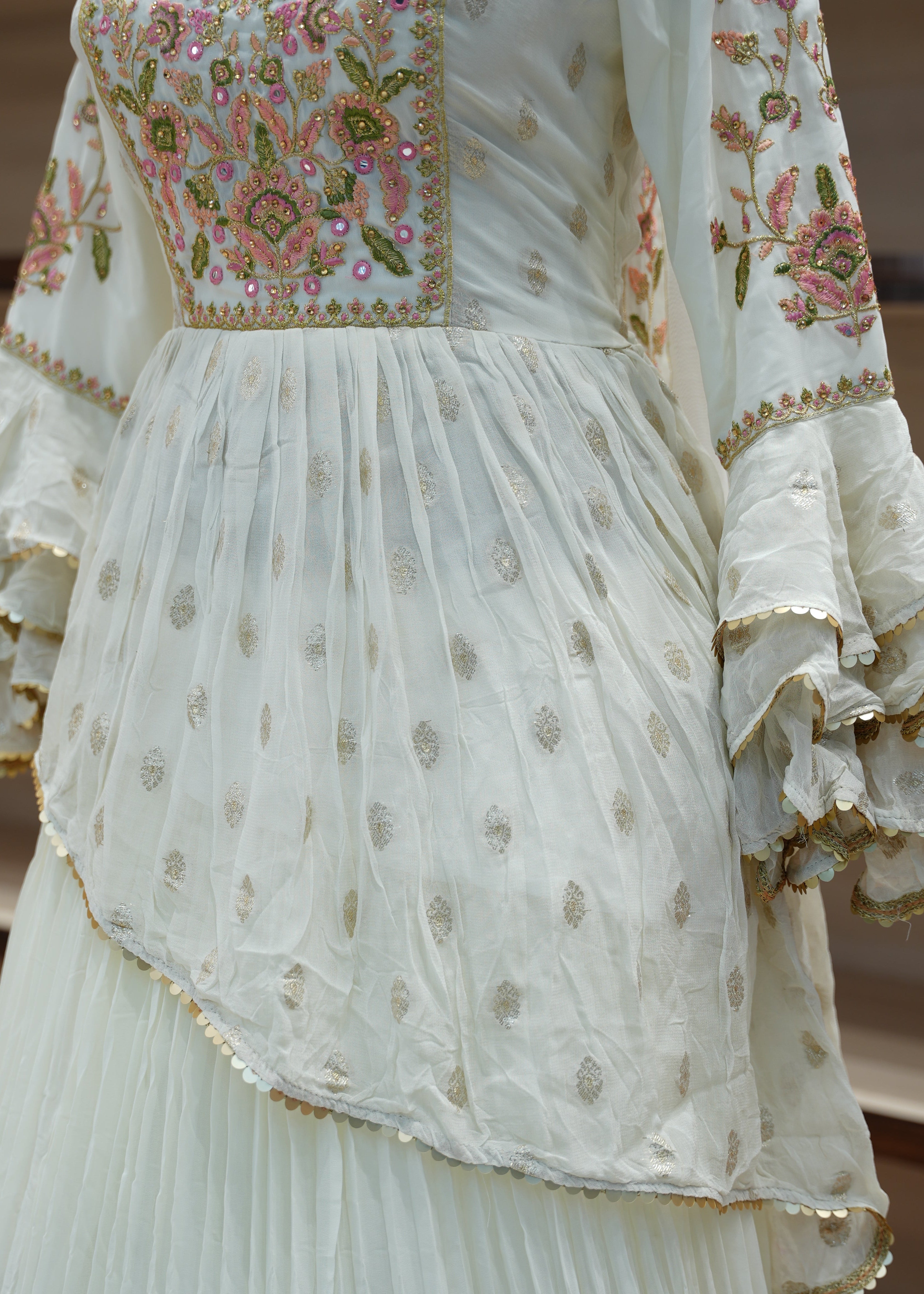 Close-up of a white embroidered dress with floral patterns on a wooden background