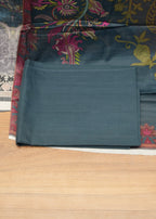 Teal fabric with floral patterns on a wooden floor