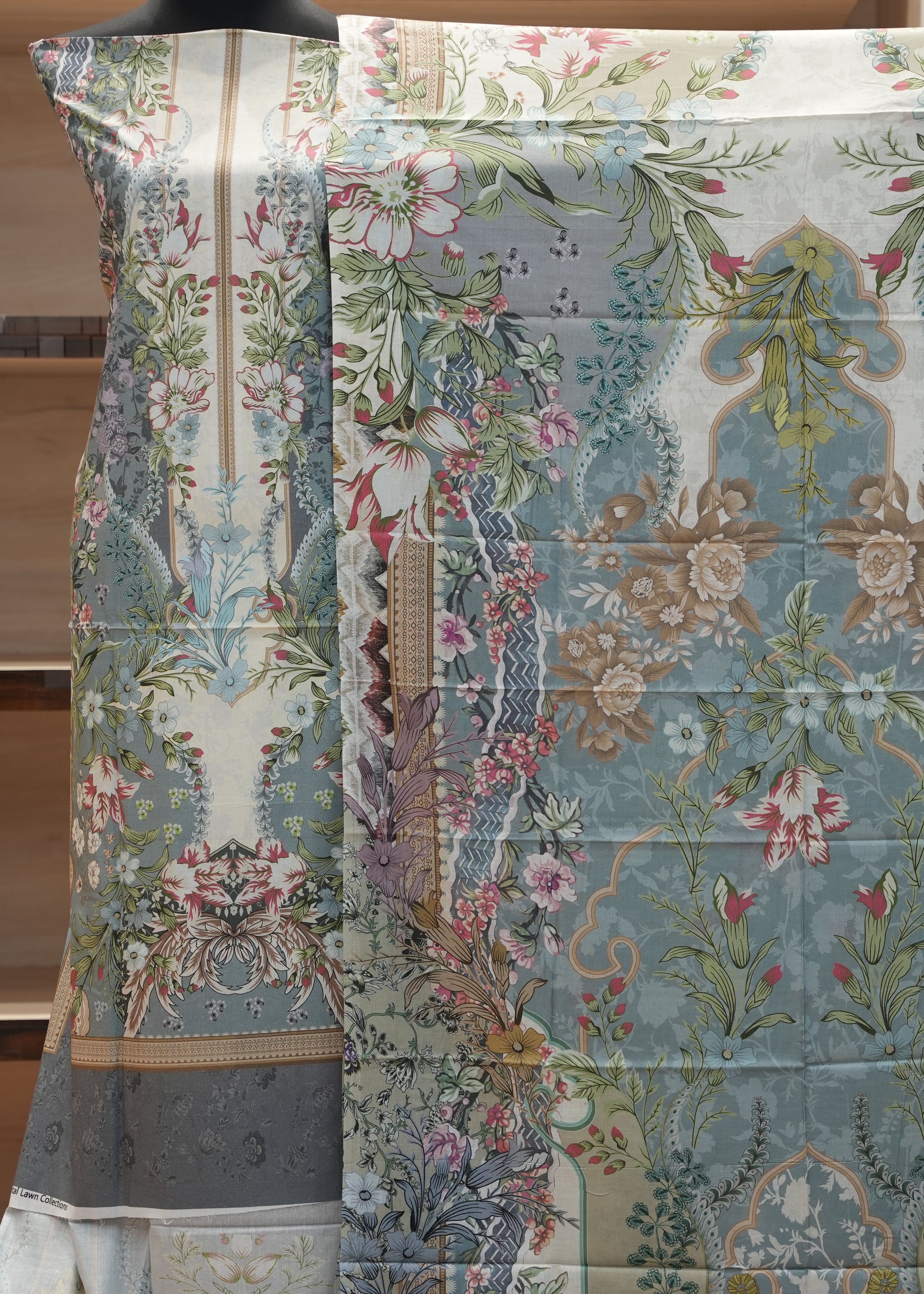Floral and nature-themed fabric with intricate patterns on a wooden background