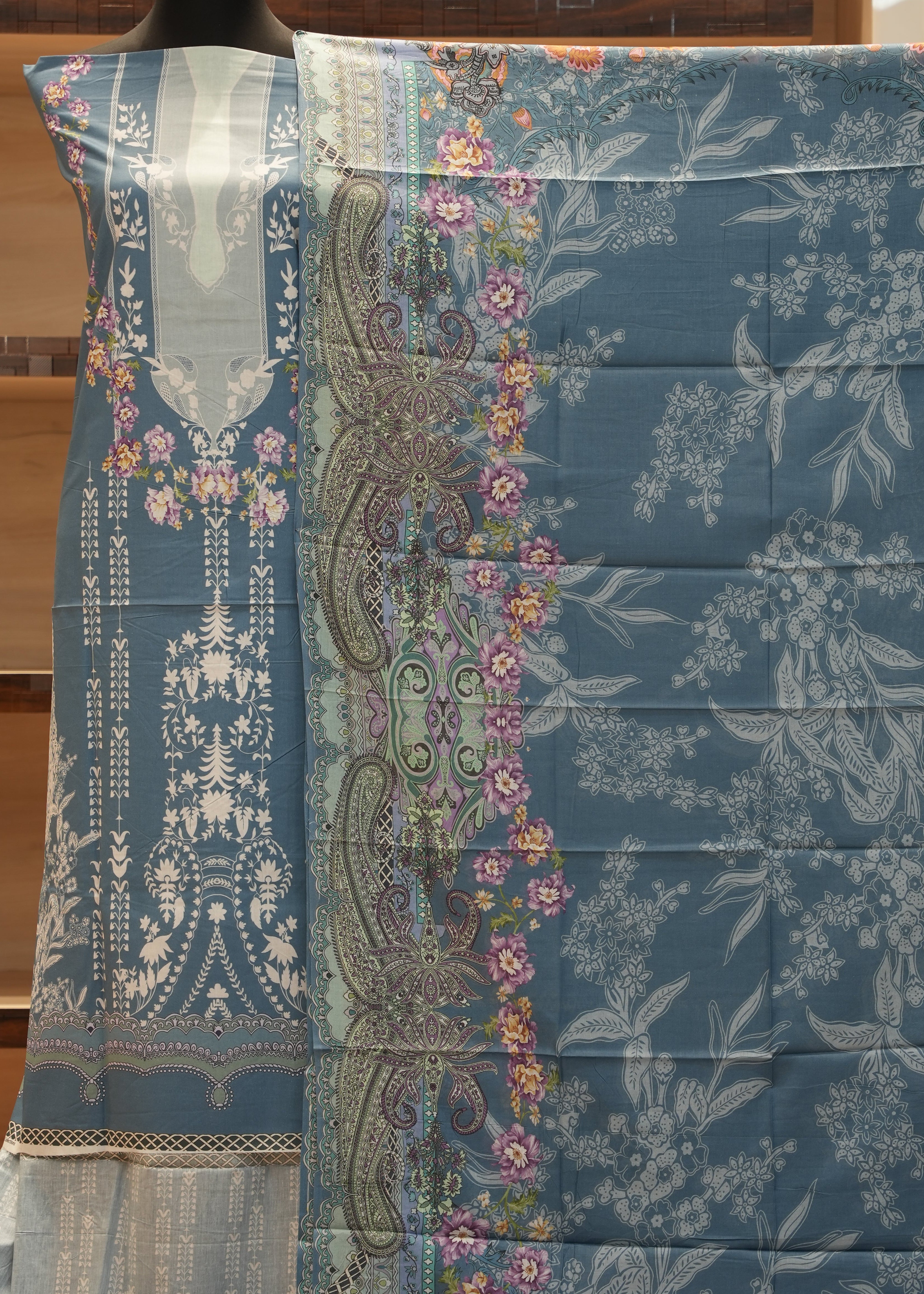 Decorative fabric with floral and paisley patterns on a wooden surface