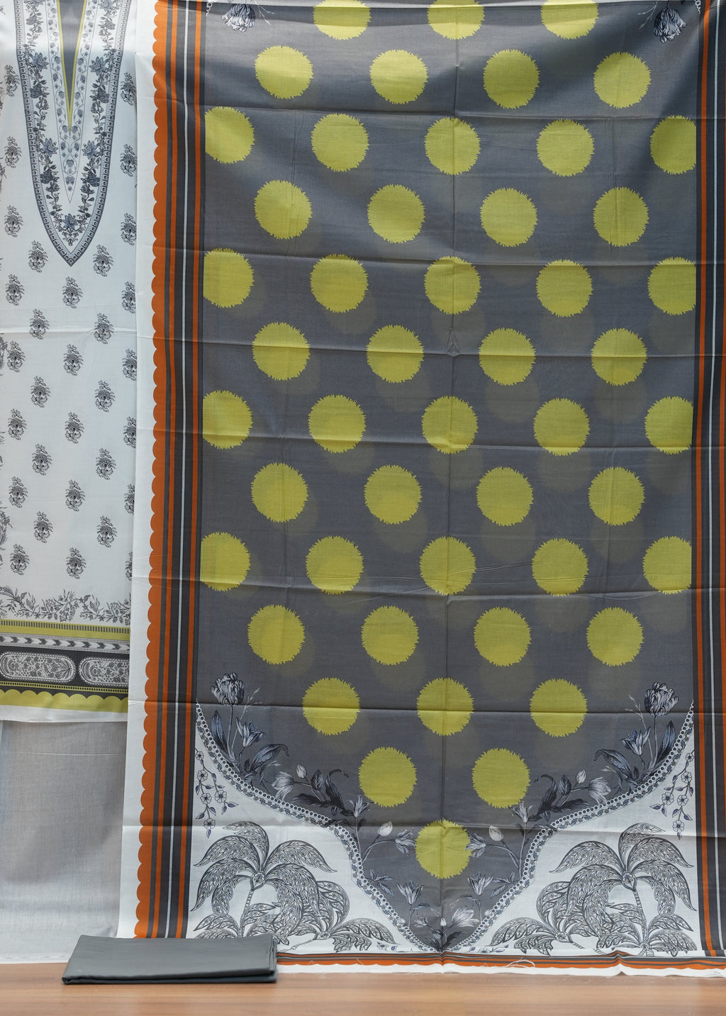 Fabric with yellow polka dots and elephant patterns on a wooden background