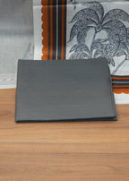 Gray fabric on a wooden surface with a patterned fabric in the background