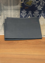 Black folder on a wooden surface with a patterned fabric background