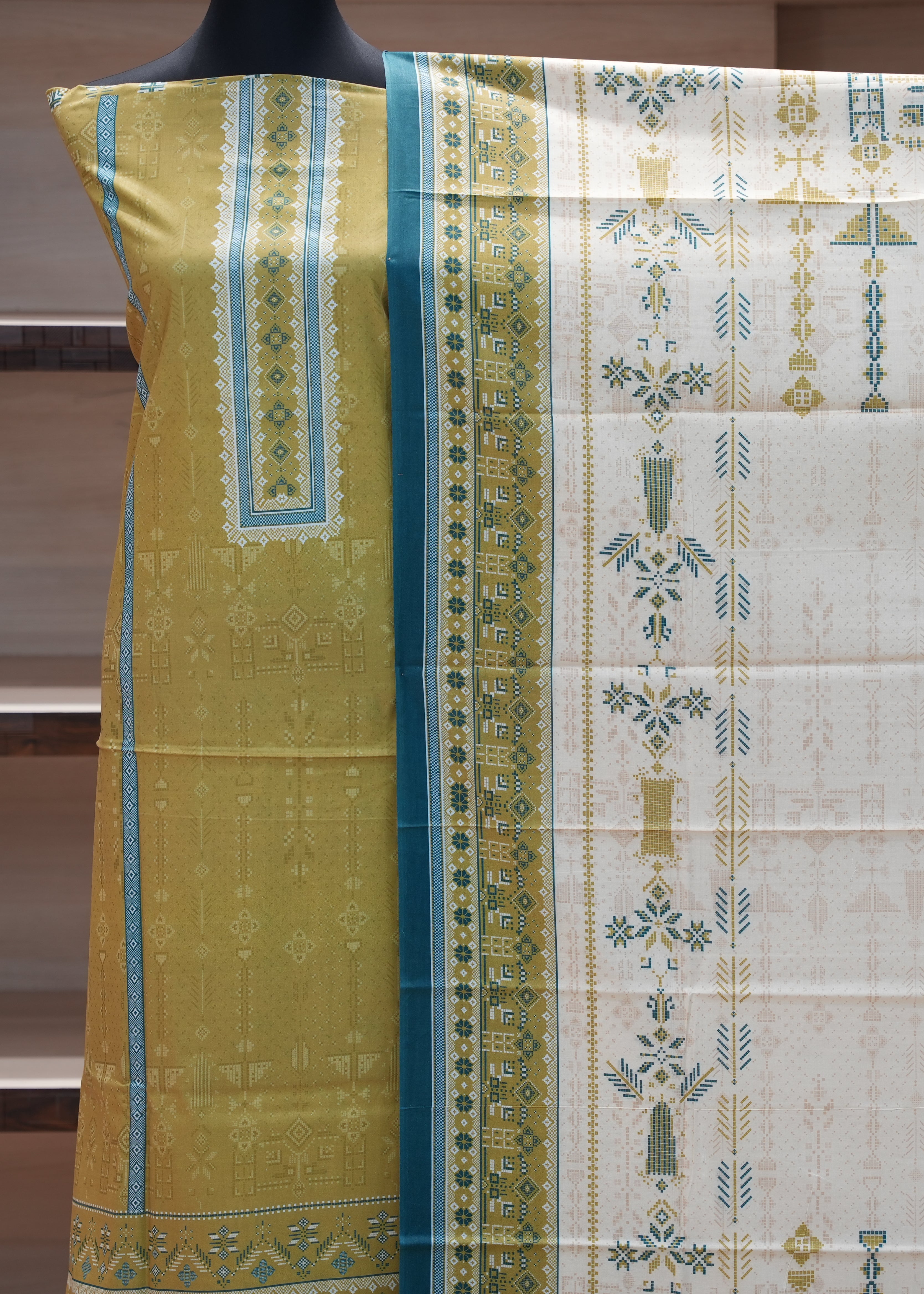 Saree with green and white patterned border on a mannequin