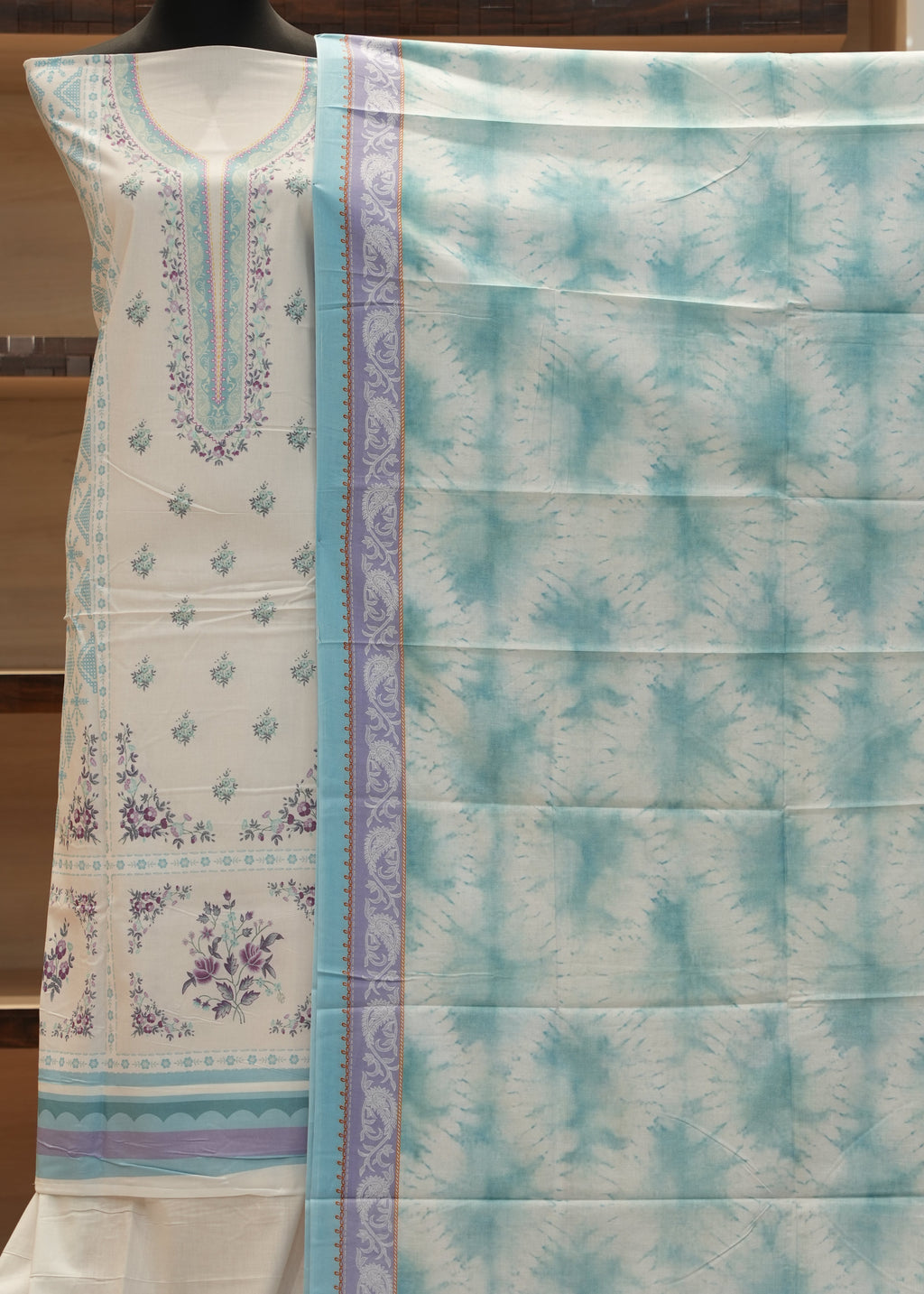 Floral-patterned bedspread with a checkered design on a wooden background