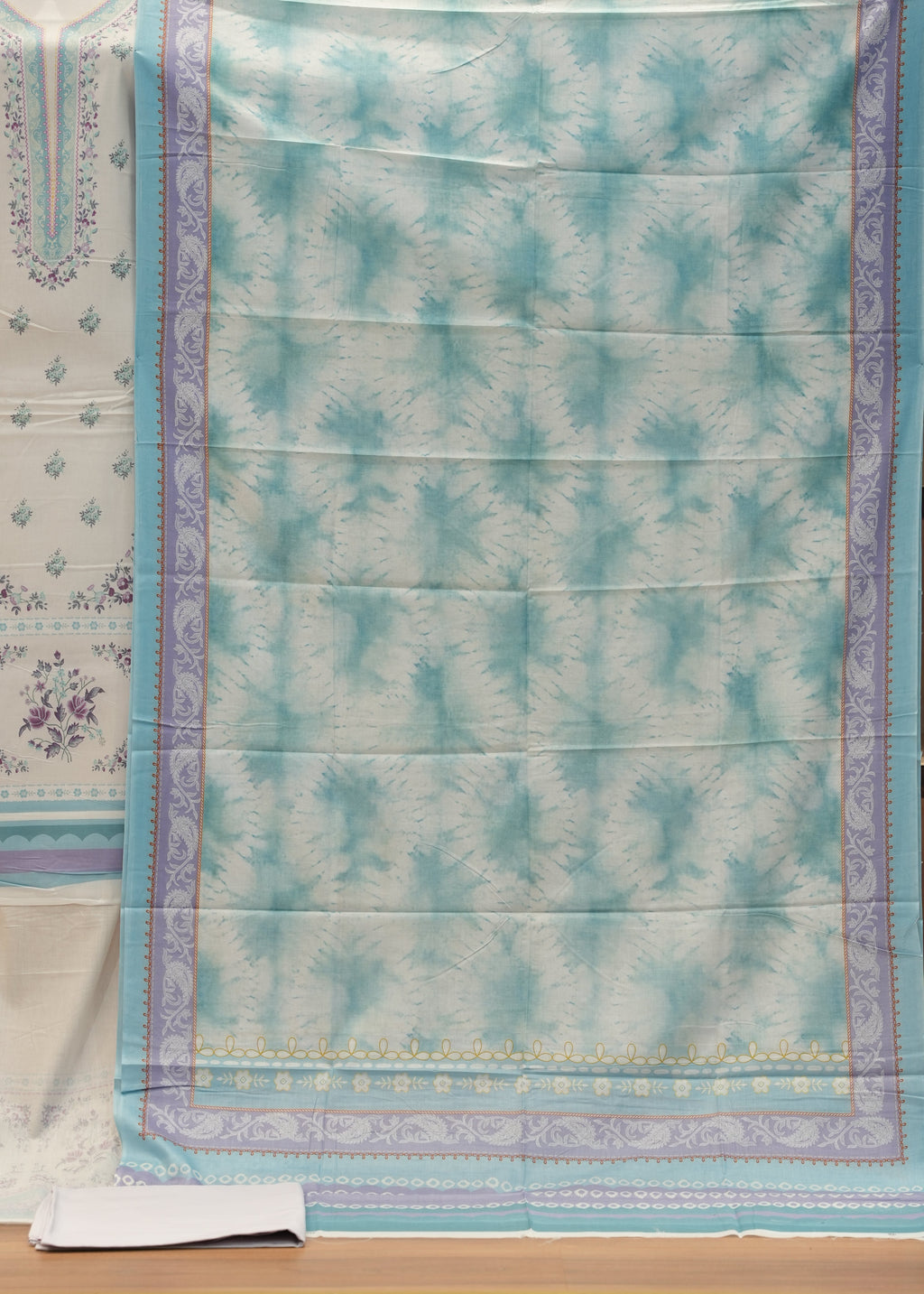 Teal and white patterned fabric on a wooden surface