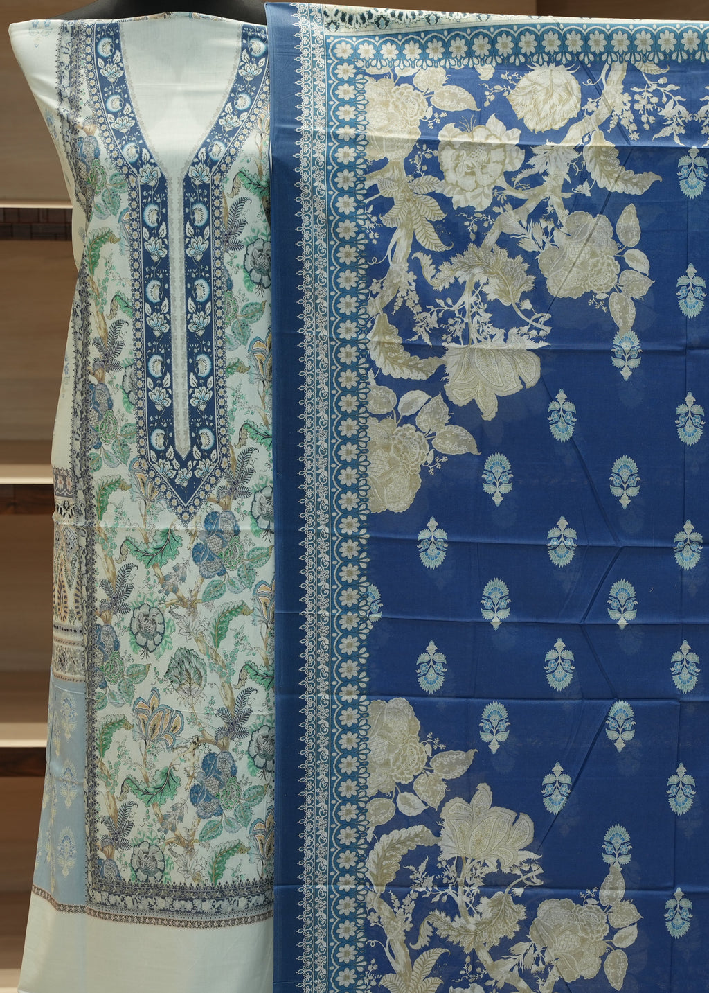 Blue and white floral patterned fabric with a green border on a wooden surface.
