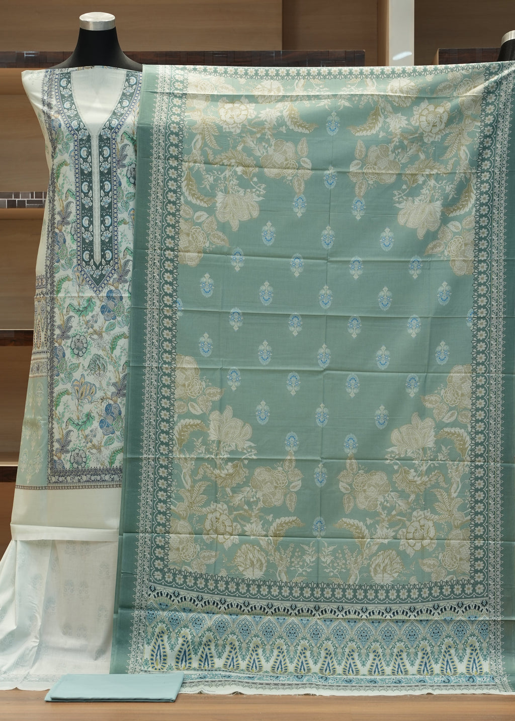 Green patterned fabric on a wooden hanger against a wooden background