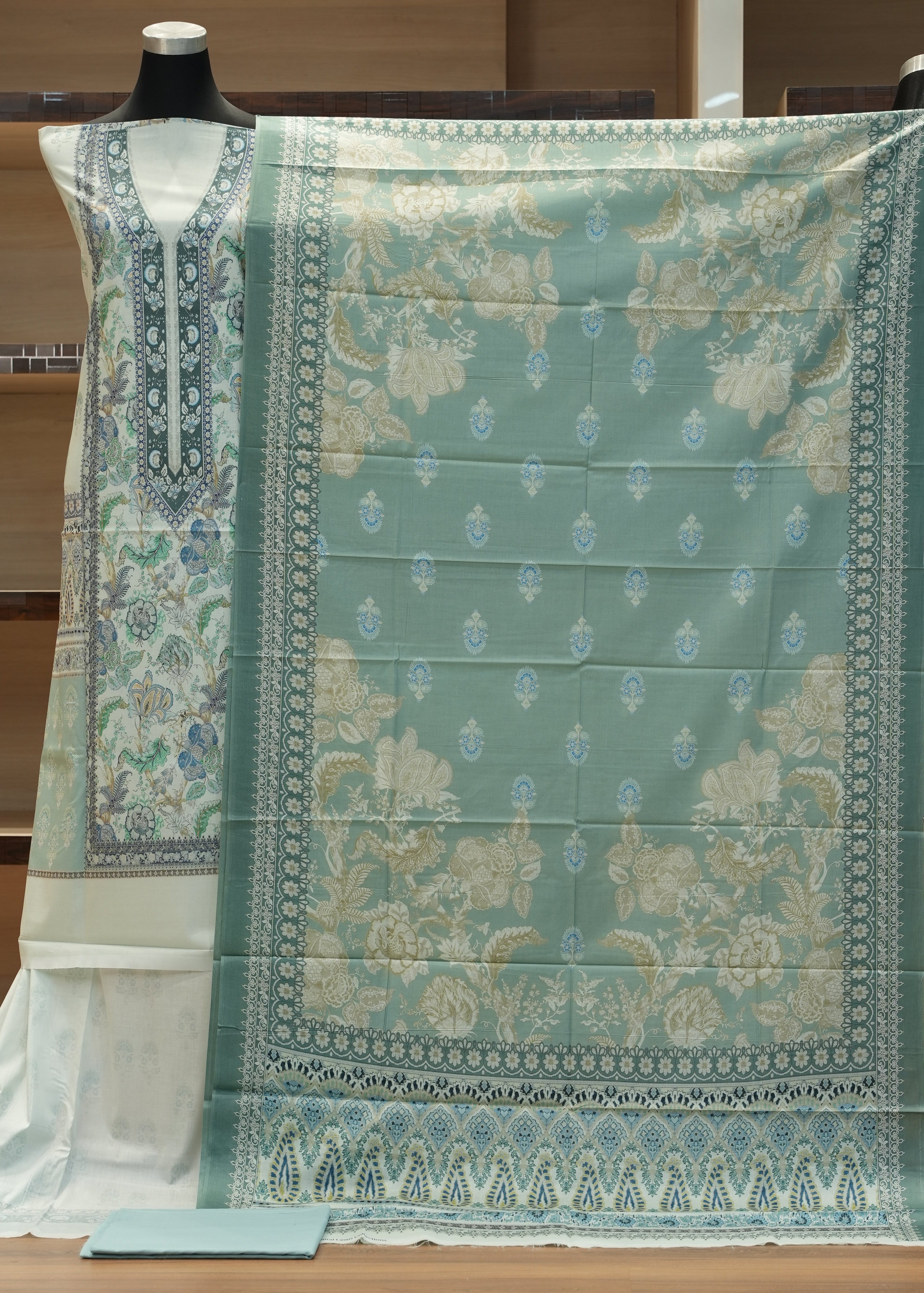 Green patterned fabric on a wooden hanger against a wooden background