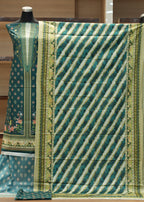 Green and white patterned fabric on a mannequin with a blurred indoor background