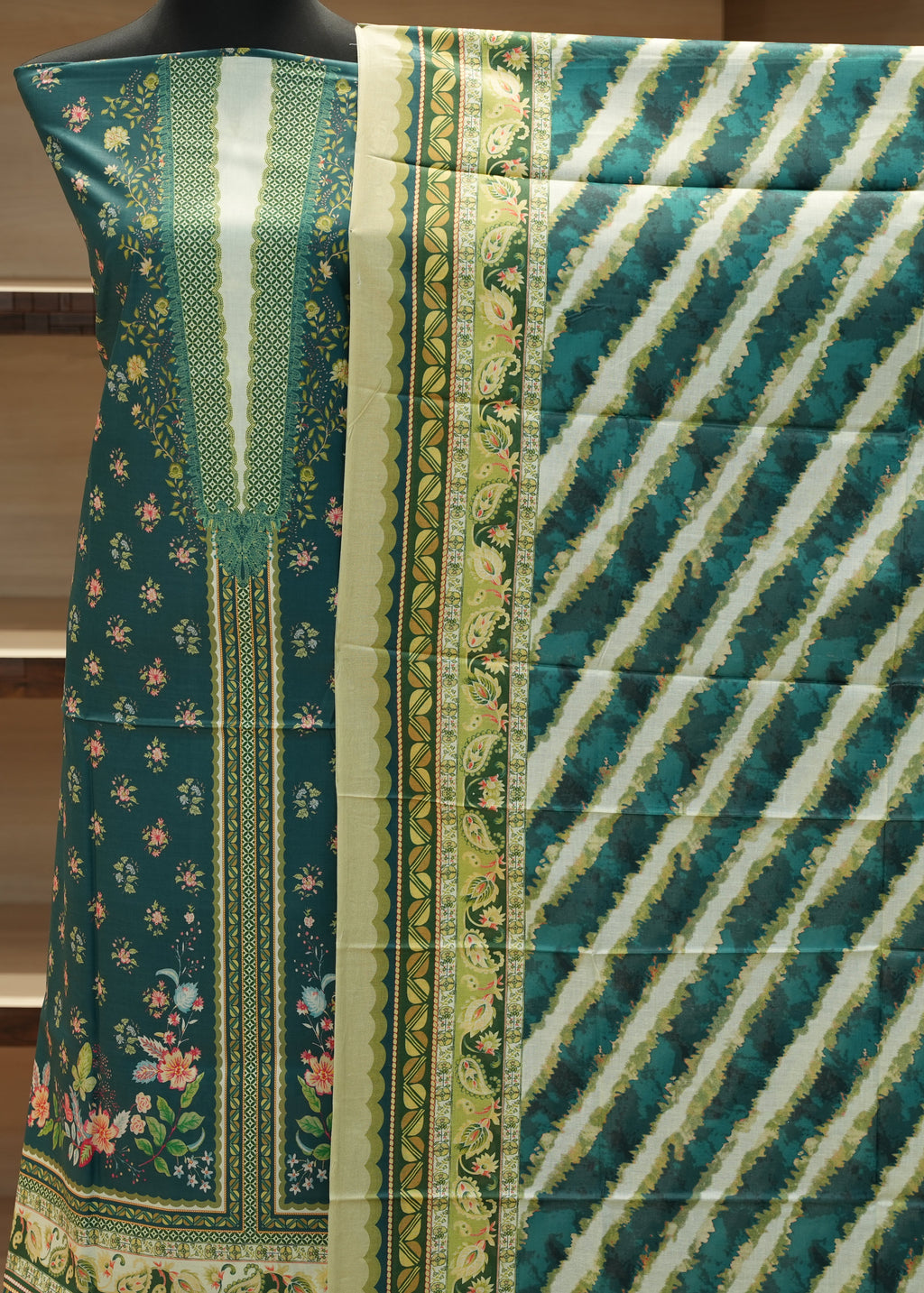 Green fabric with floral patterns and diagonal stripes on a mannequin.