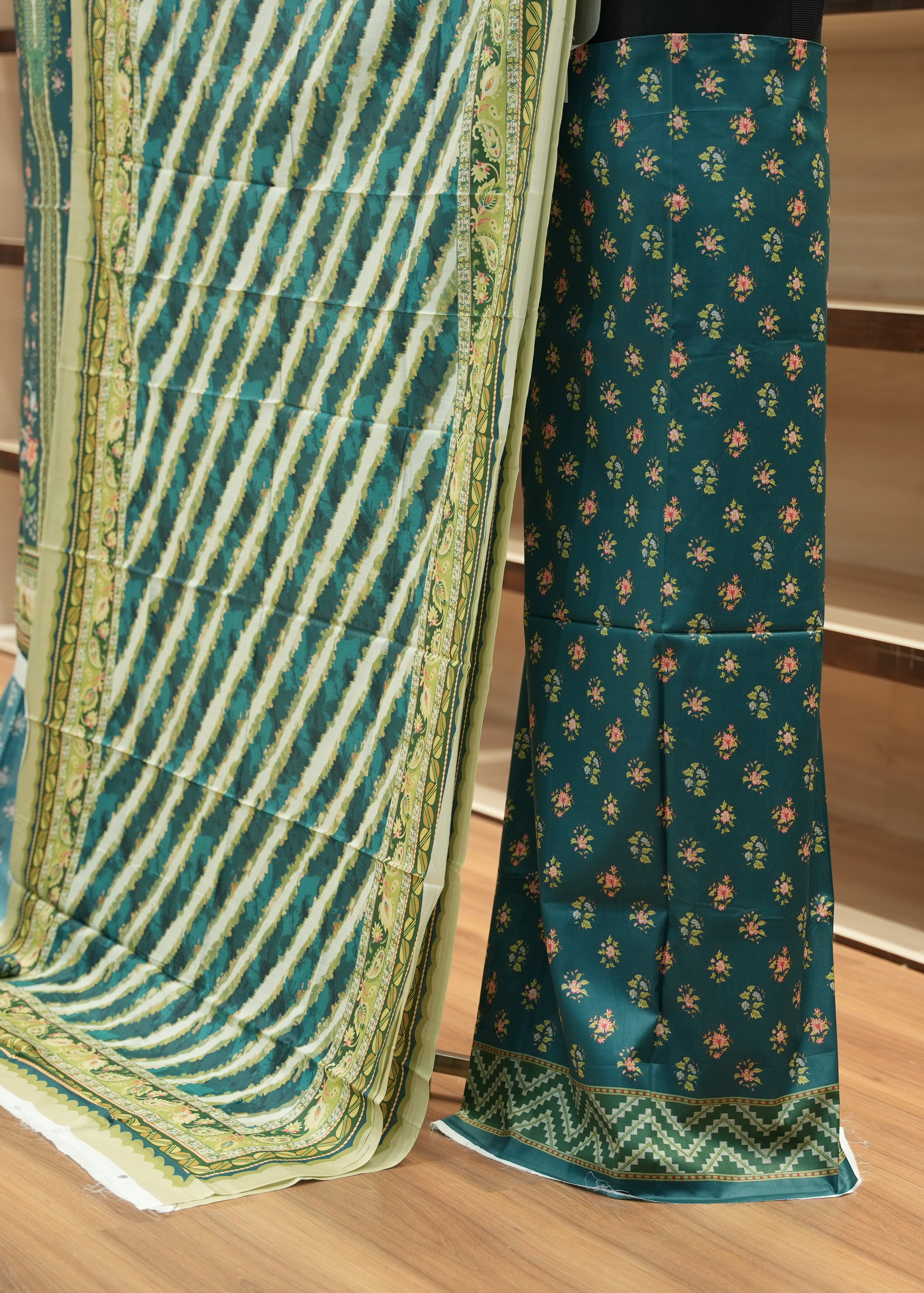 Teal saree with green border on a wooden floor