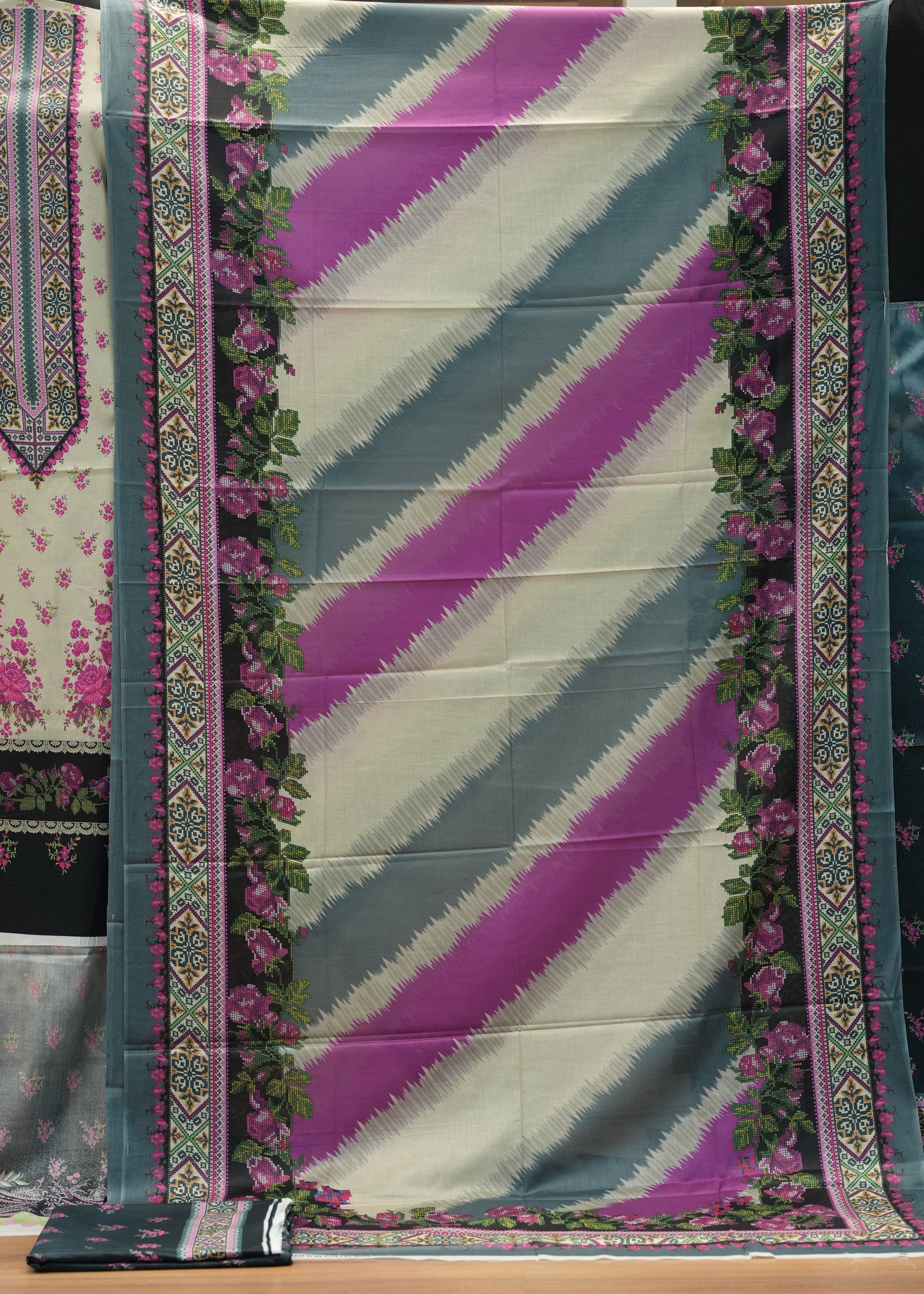 Traditional fabric with floral patterns and geometric designs on a wooden background