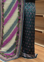 Saree with a colorful border and patterned fabric on a wooden floor.