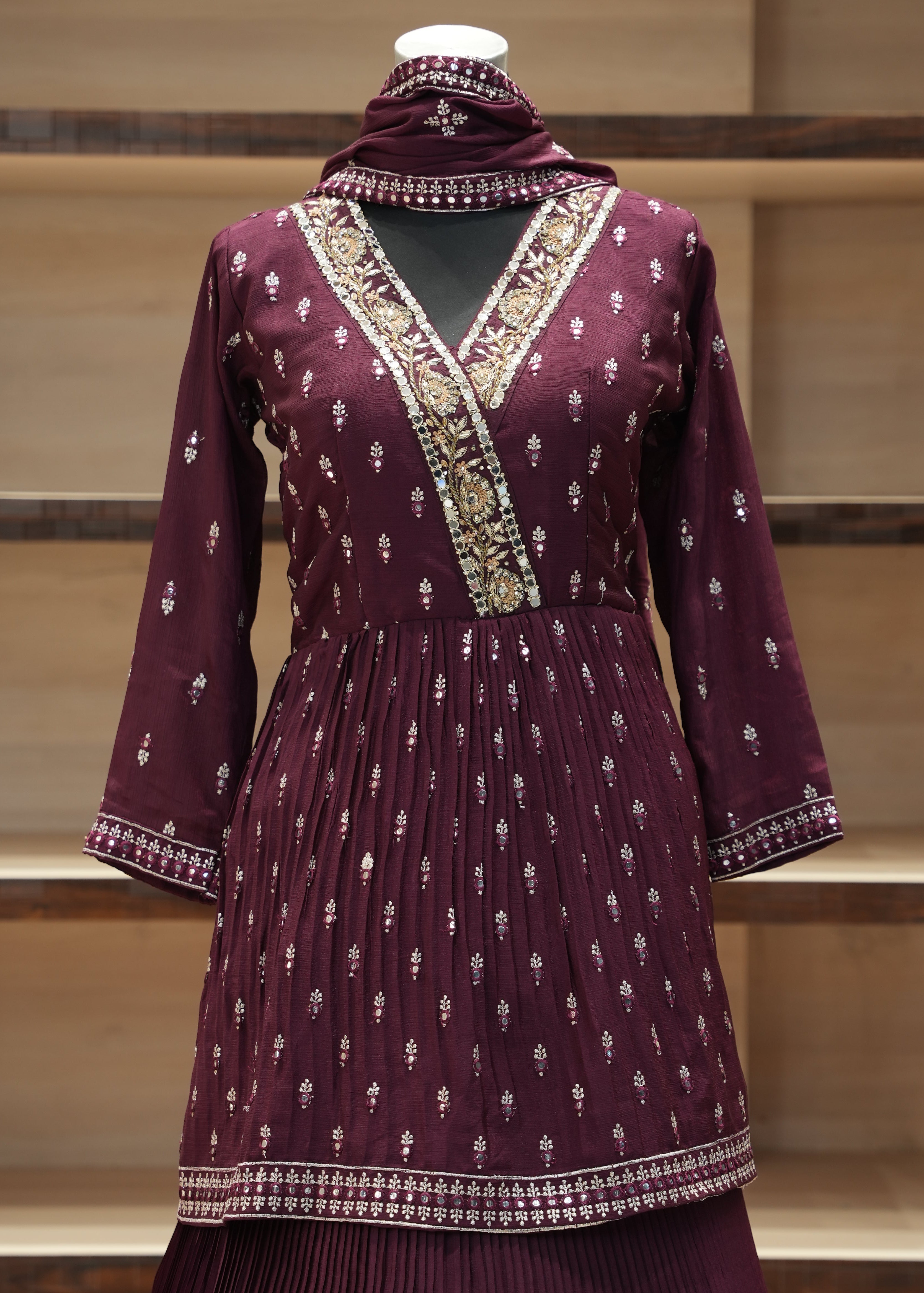 Purple traditional outfit with intricate patterns on a wooden chair.