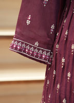 Close-up of a maroon fabric with floral embroidery on a blurred background