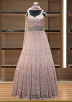 Pink evening gown with sequin details on a wooden rack