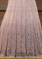 Pink sequin dress on a wooden floor with a neutral background