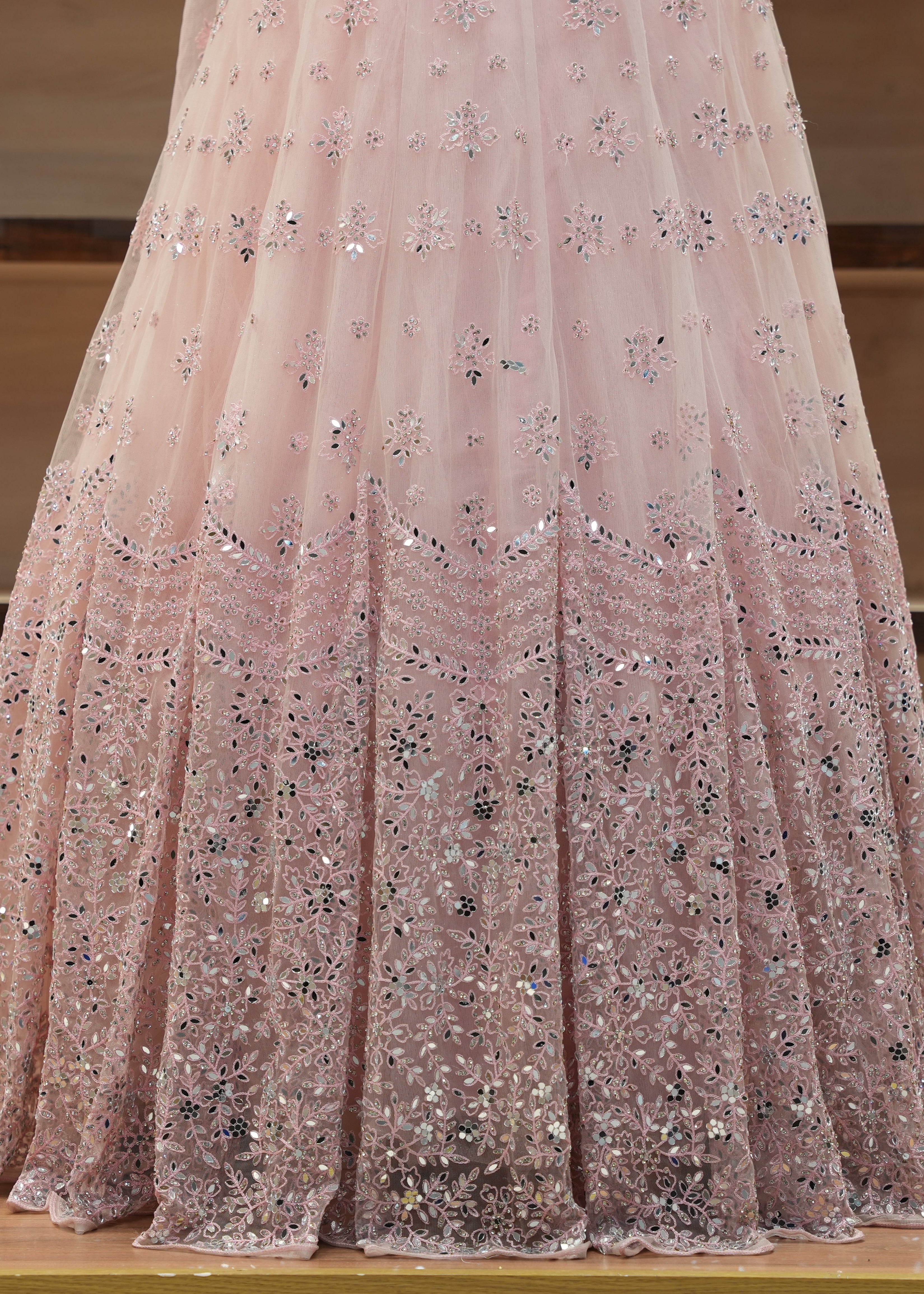 Pink sequin dress on a wooden floor with a neutral background