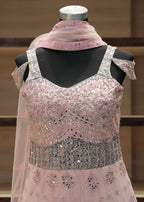 Pink embroidered dress on a mannequin against a neutral background