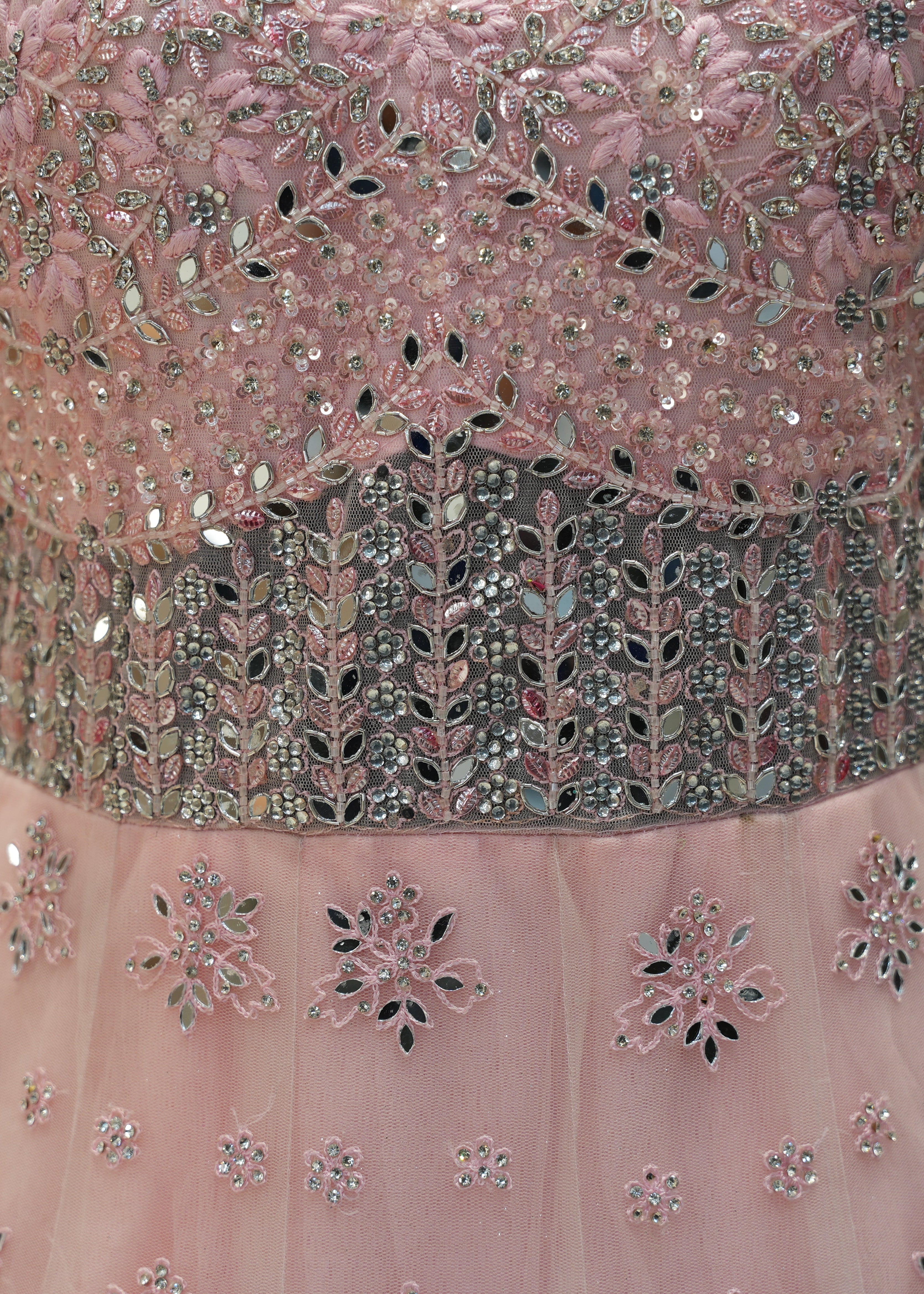 Close-up of a pink dress with intricate silver beadwork on a blurred background