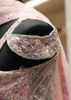 Close-up of a pink embroidered garment with intricate designs.