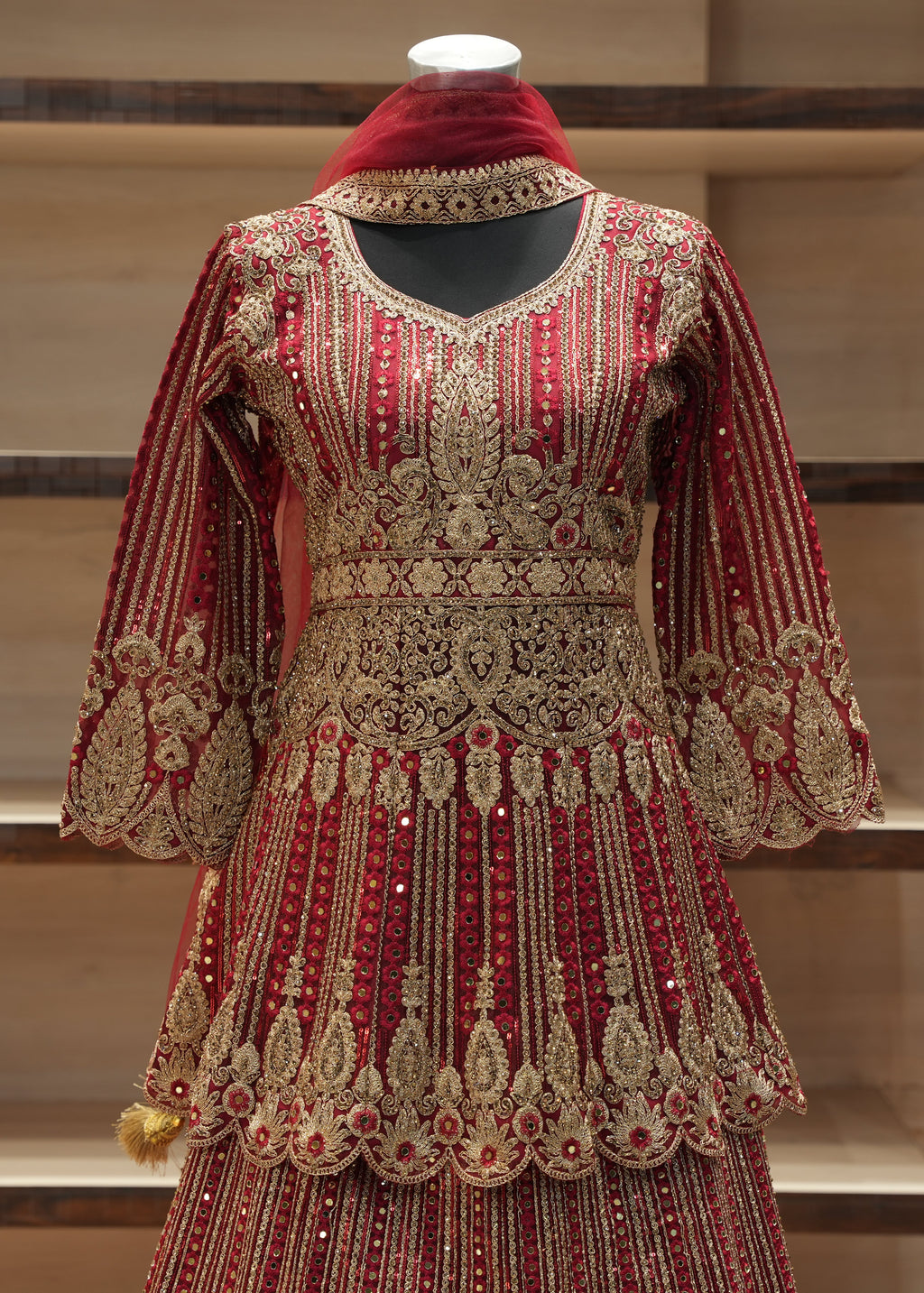 Decorative red and gold traditional outfit on a mannequin against a neutral background