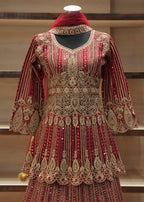 Decorative red and gold traditional outfit on a mannequin against a neutral background