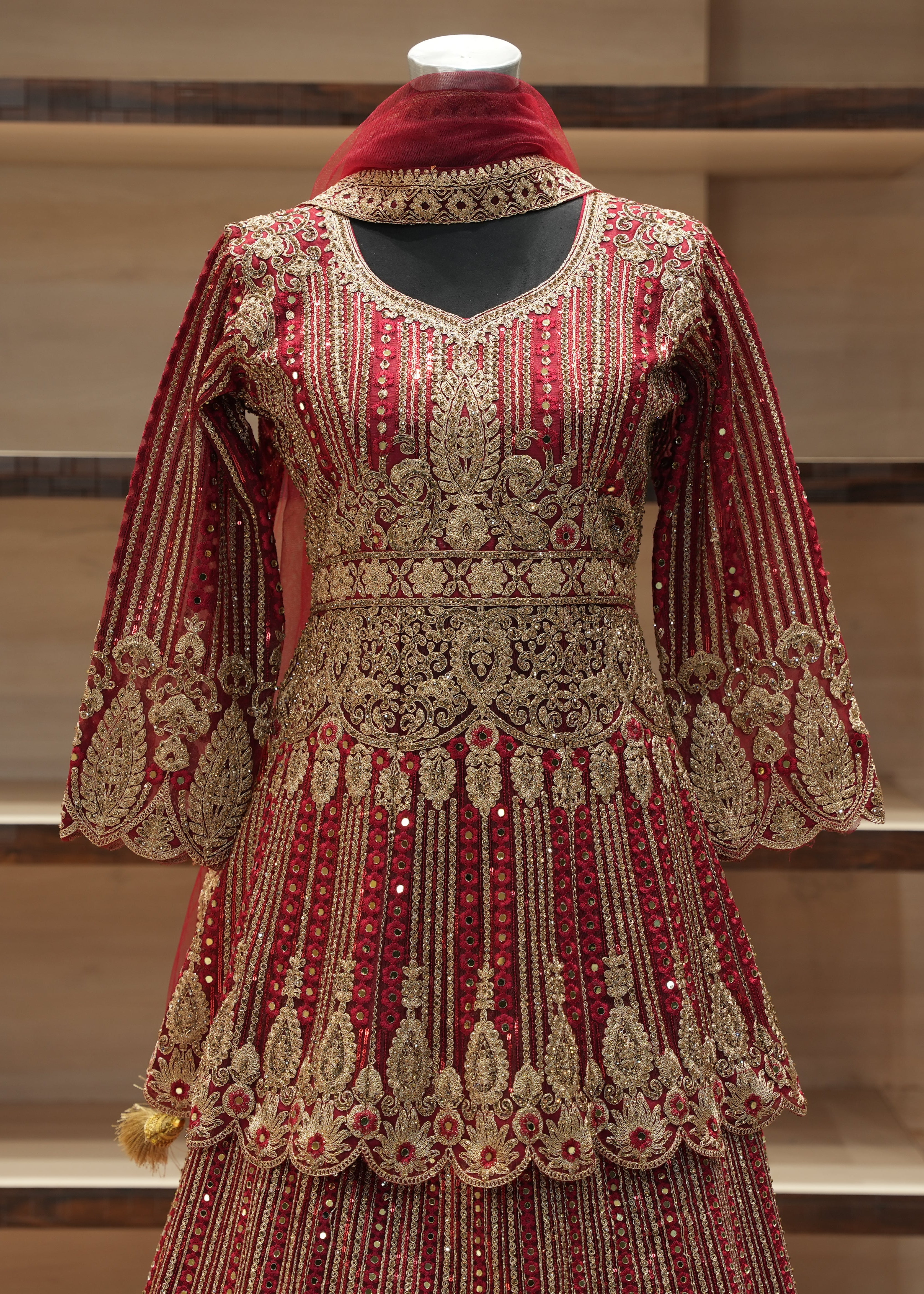 Decorative red and gold traditional outfit on a mannequin against a neutral background