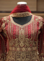 Decorative red and gold garment with intricate patterns on a mannequin.