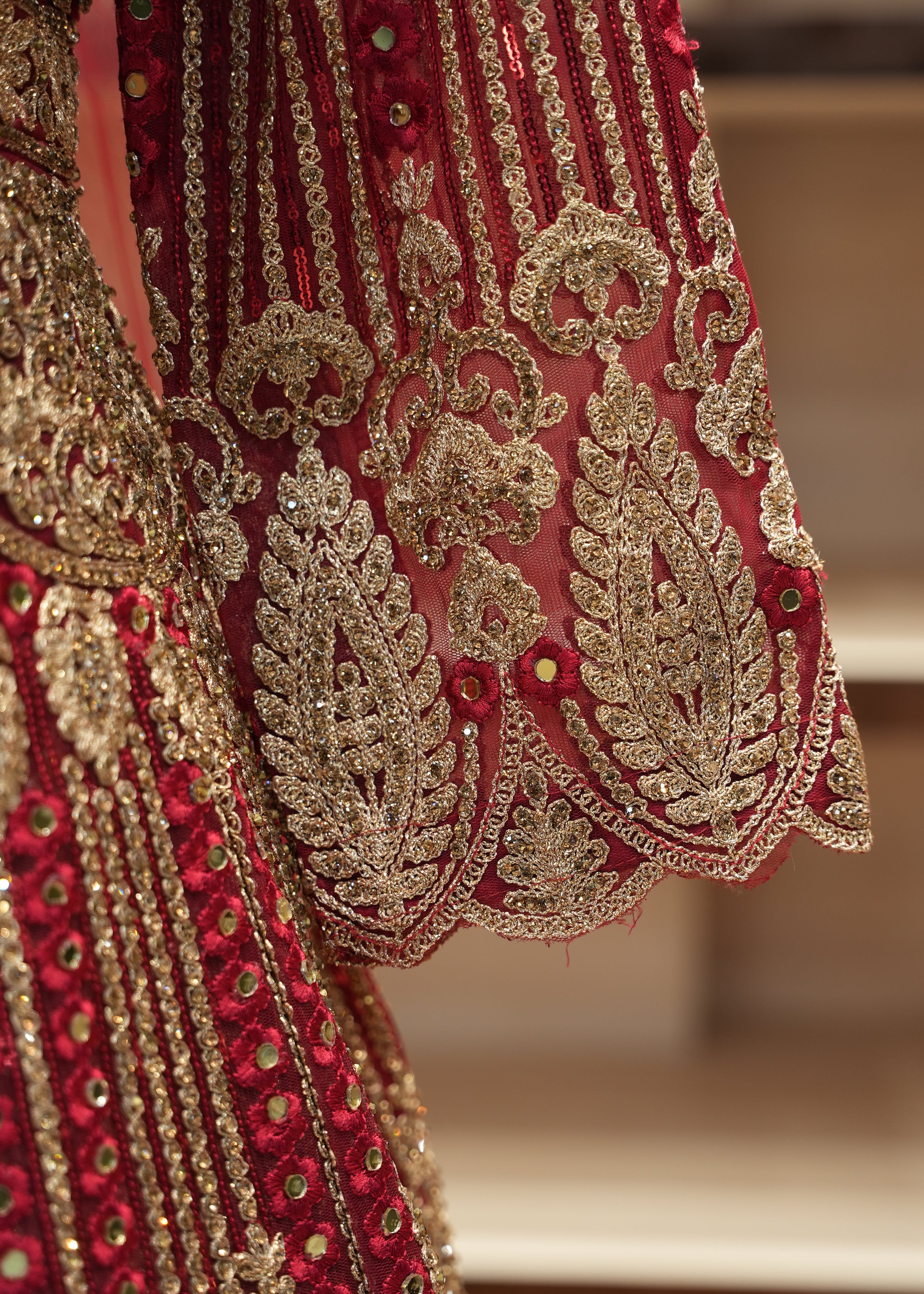 Close-up of red fabric with gold embroidery on a blurred background