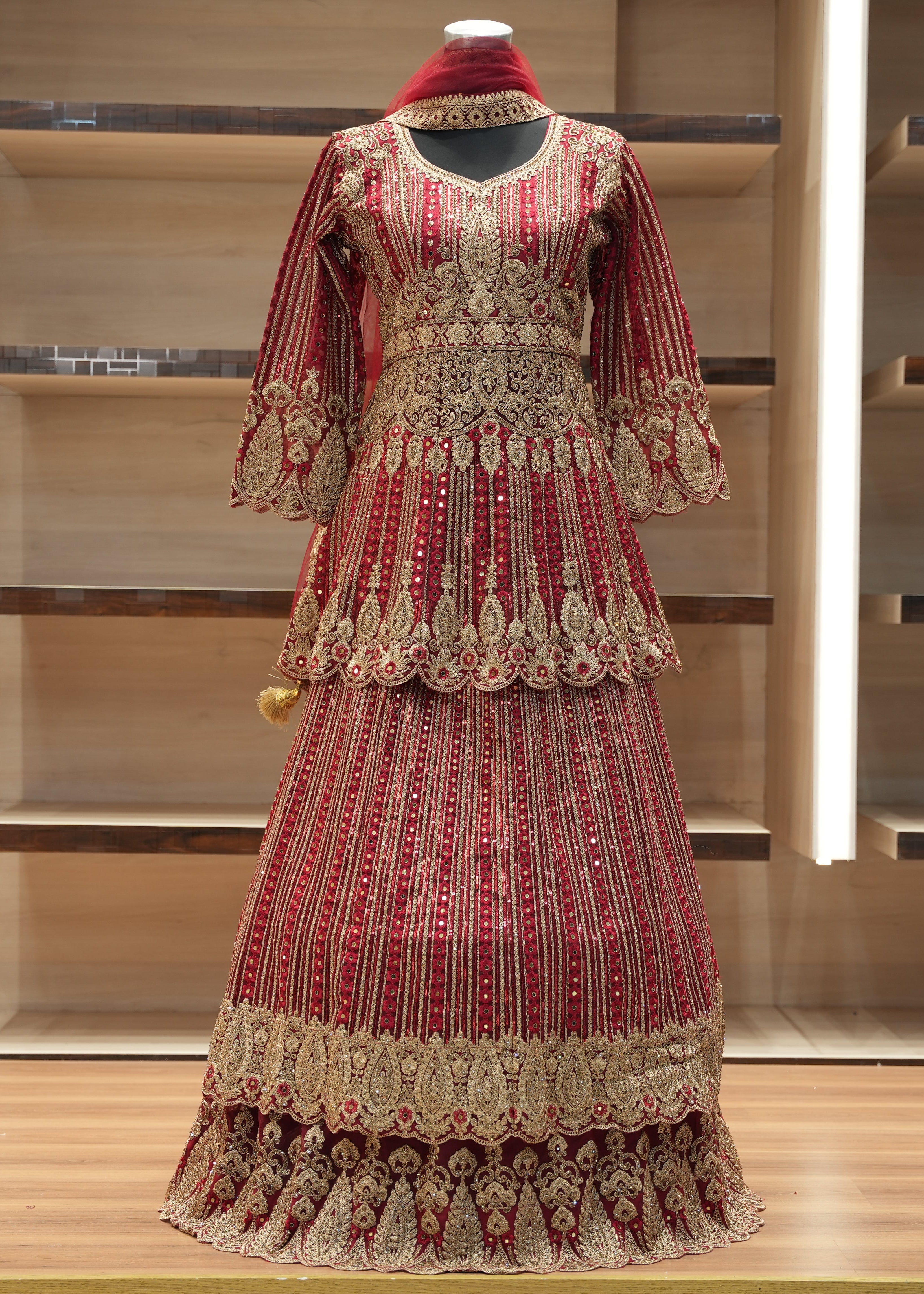 Decorative red and gold traditional outfit on a mannequin against a wooden background