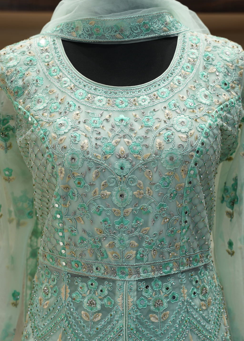 Light blue embroidered traditional outfit with a sheer overlay on a neutral background