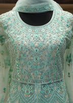 Light blue embroidered traditional outfit with a sheer overlay on a neutral background