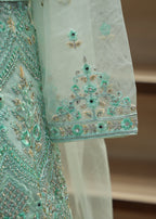 Close-up of a turquoise embroidered fabric with intricate patterns