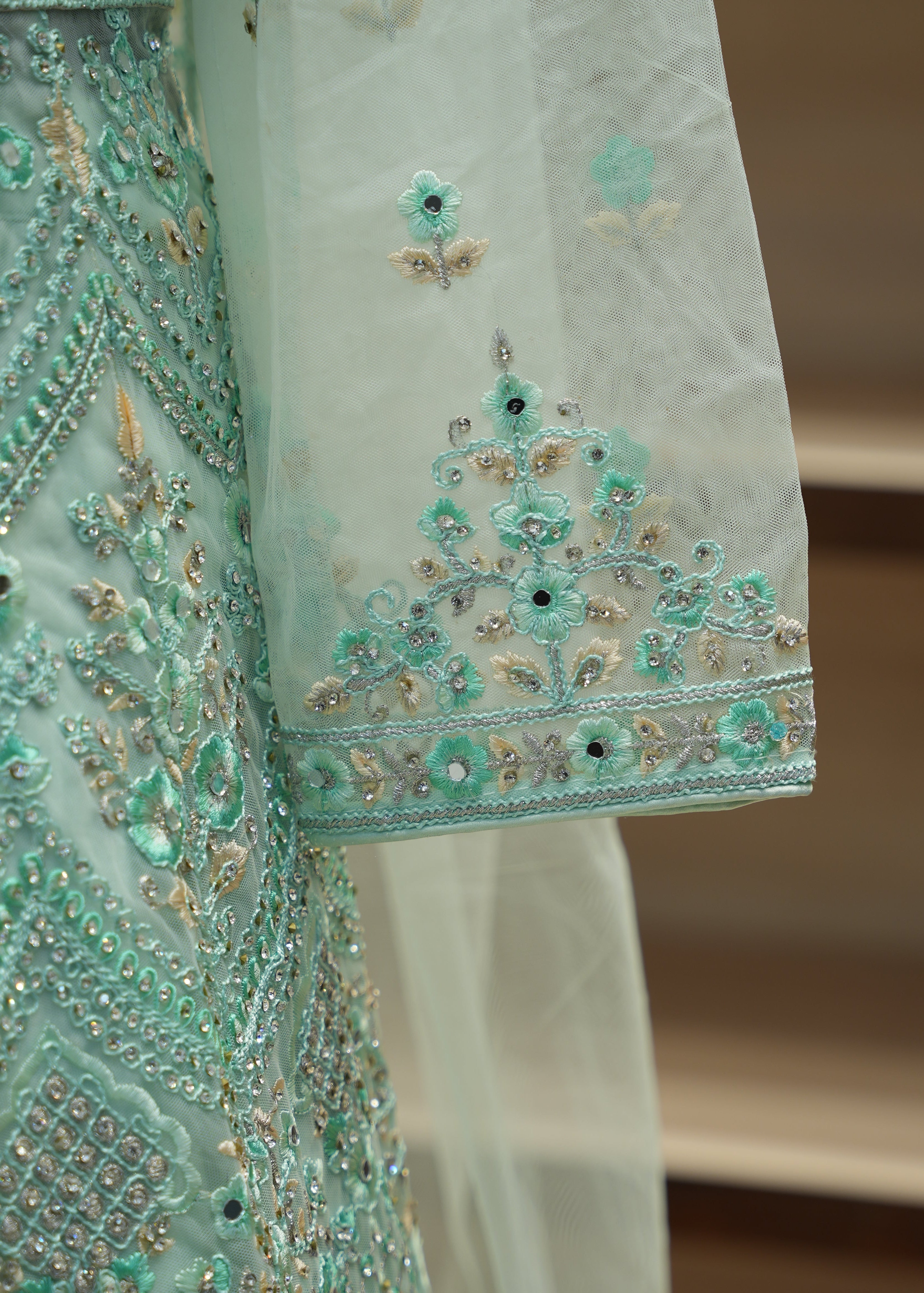 Close-up of a turquoise embroidered fabric with intricate patterns