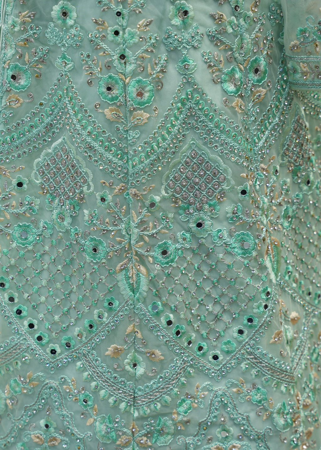 Close-up of a teal embroidered fabric with intricate patterns