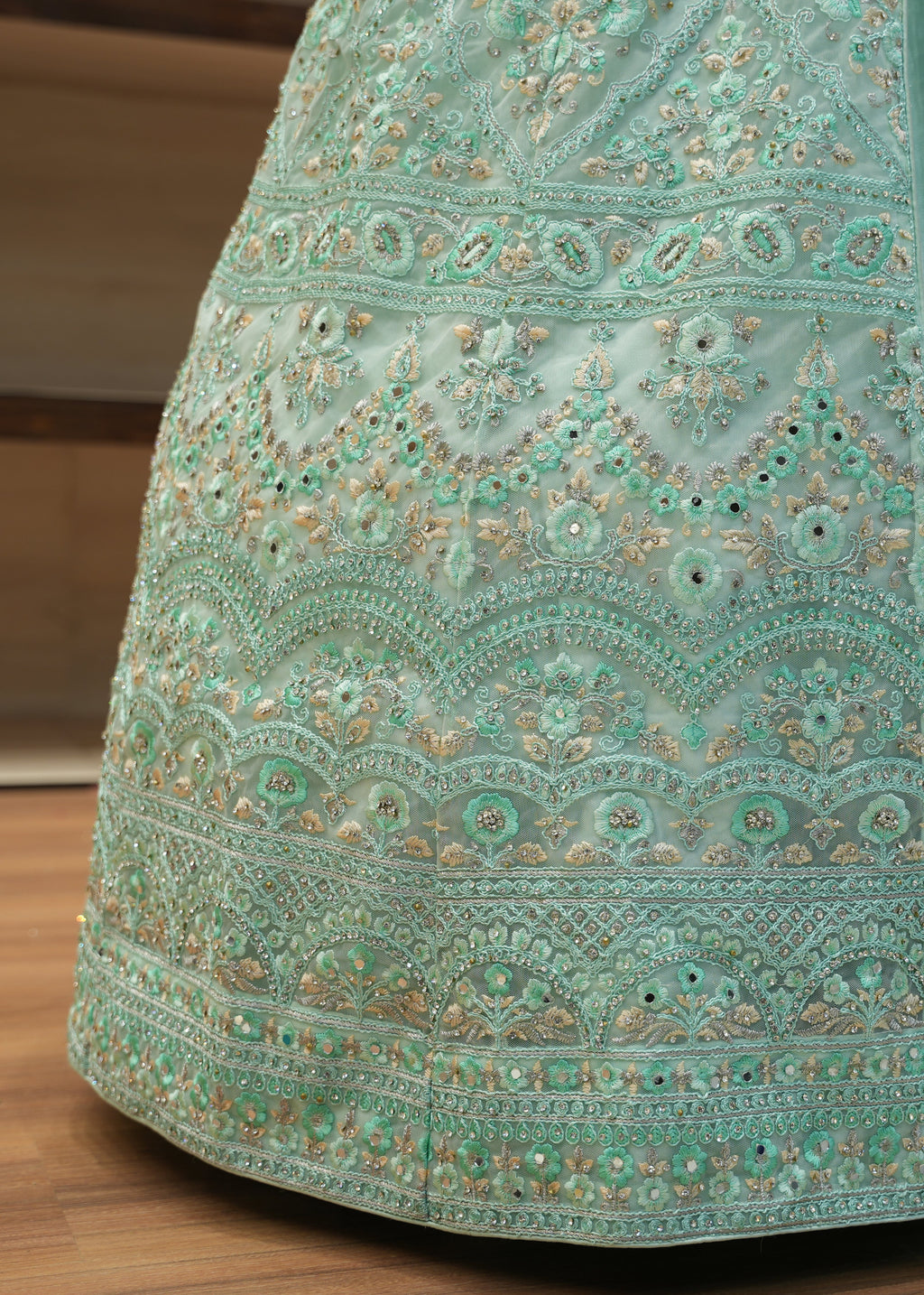 Teal embroidered fabric on a wooden surface