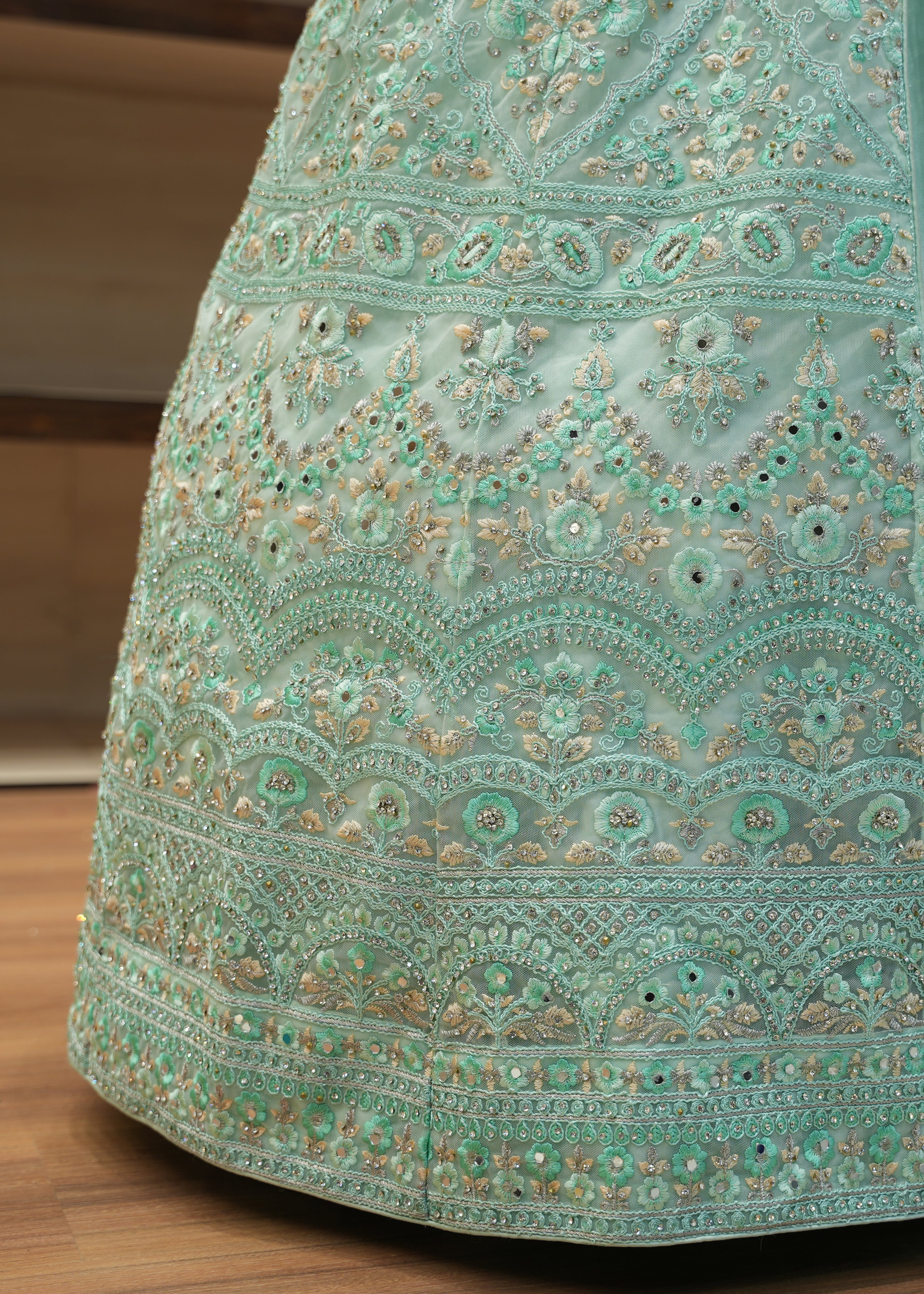 Teal embroidered fabric on a wooden surface