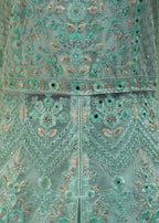 Close-up of a teal embroidered garment with intricate patterns