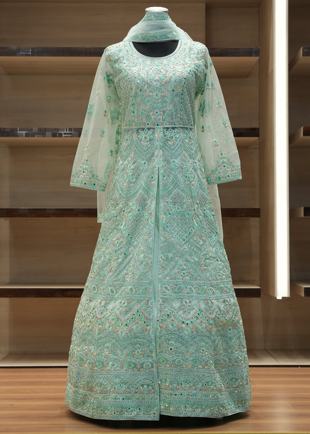 Green patterned dress on a mannequin against a wooden background