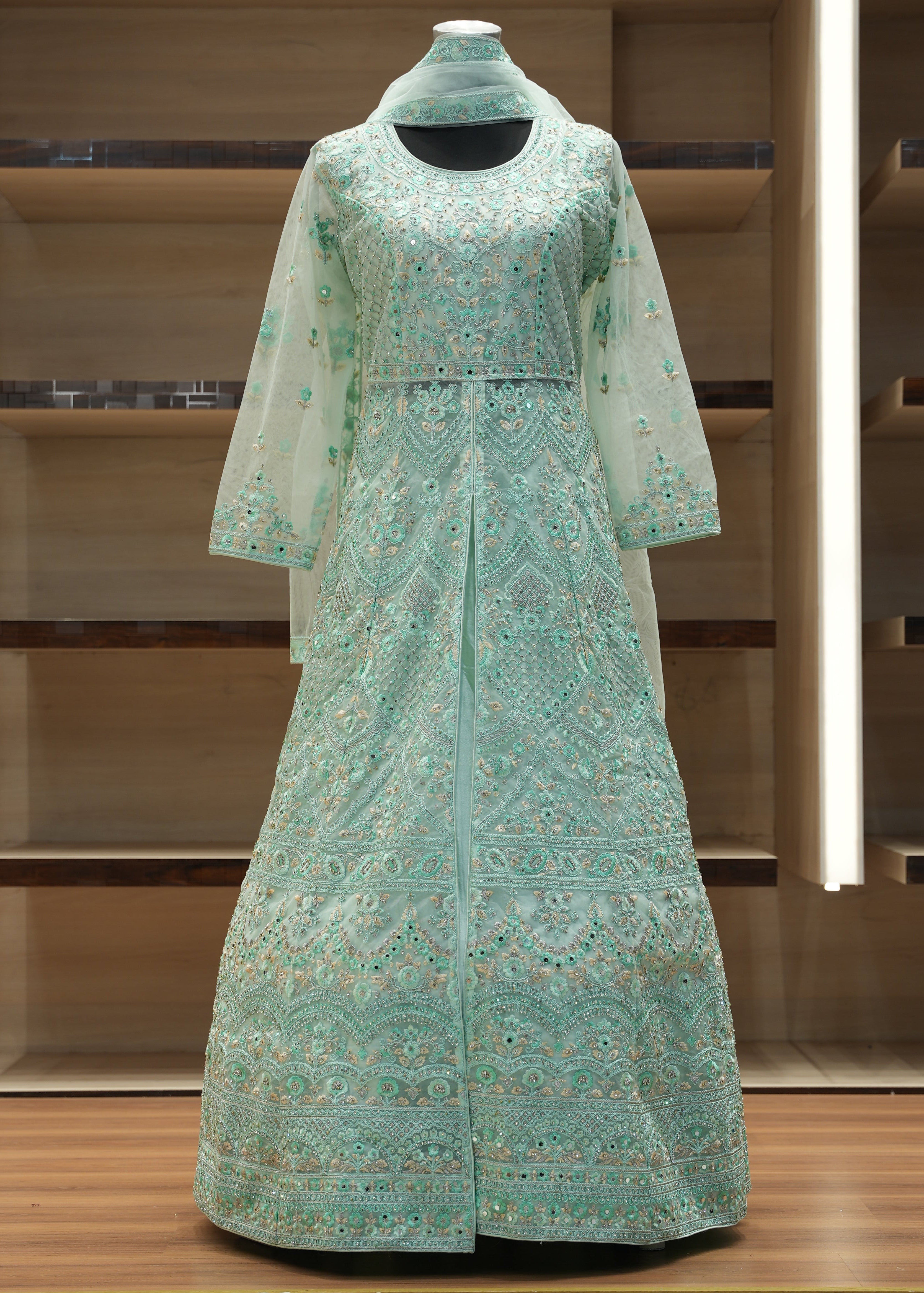 Green patterned dress on a mannequin against a wooden background