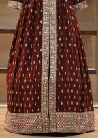 Maroon traditional outfit with intricate white and pink patterns on a neutral background