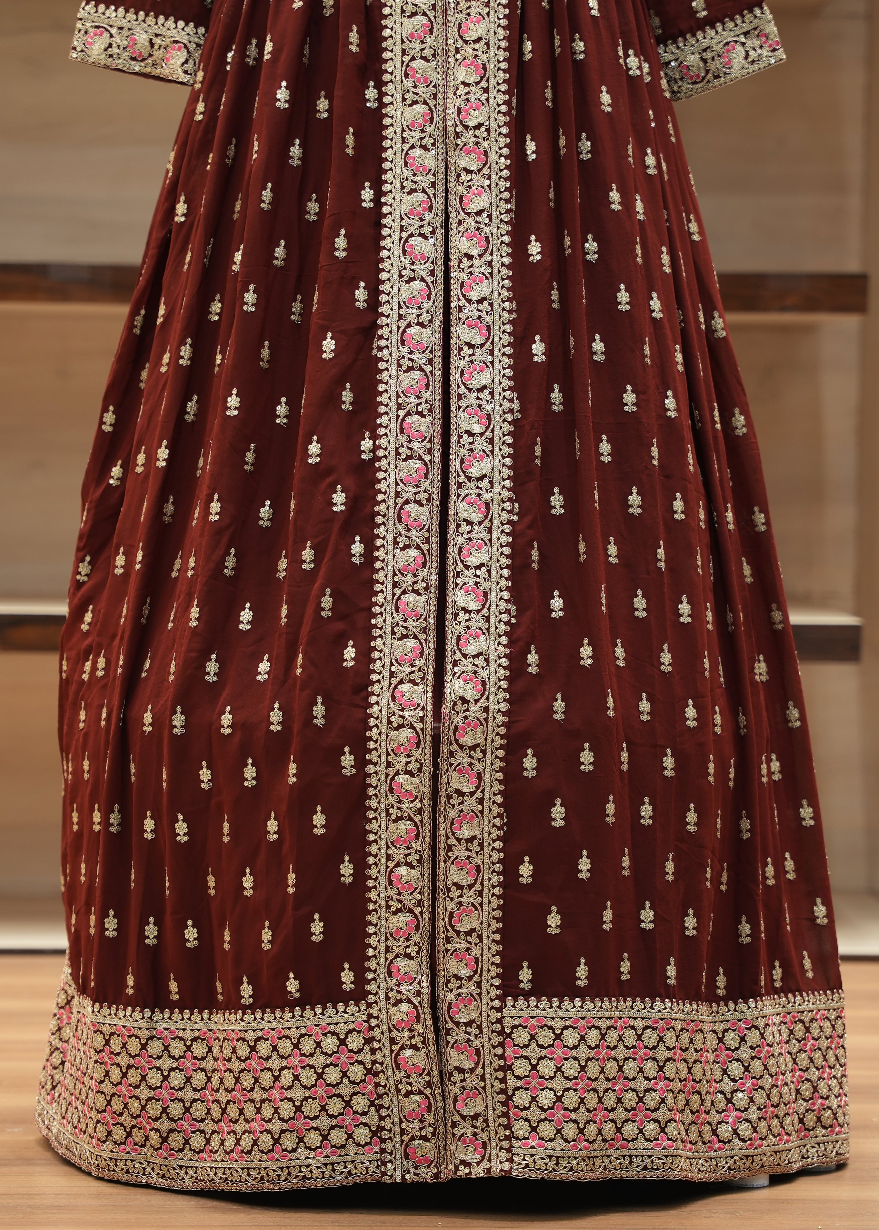 Maroon traditional outfit with intricate white and pink patterns on a neutral background