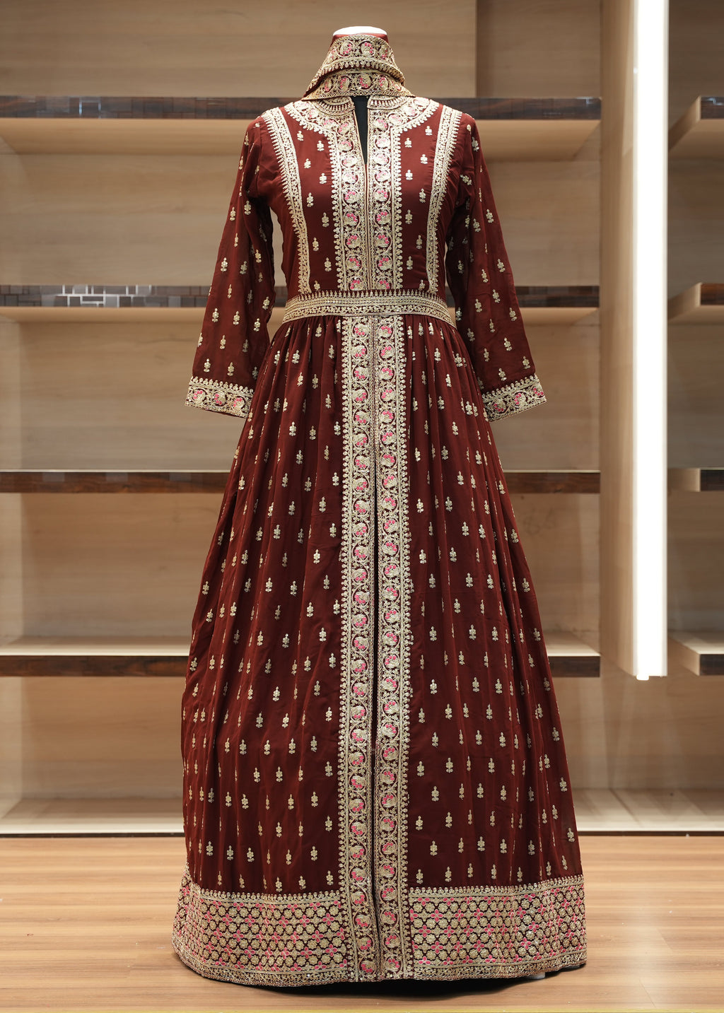Brown embroidered dress on a mannequin against a neutral background