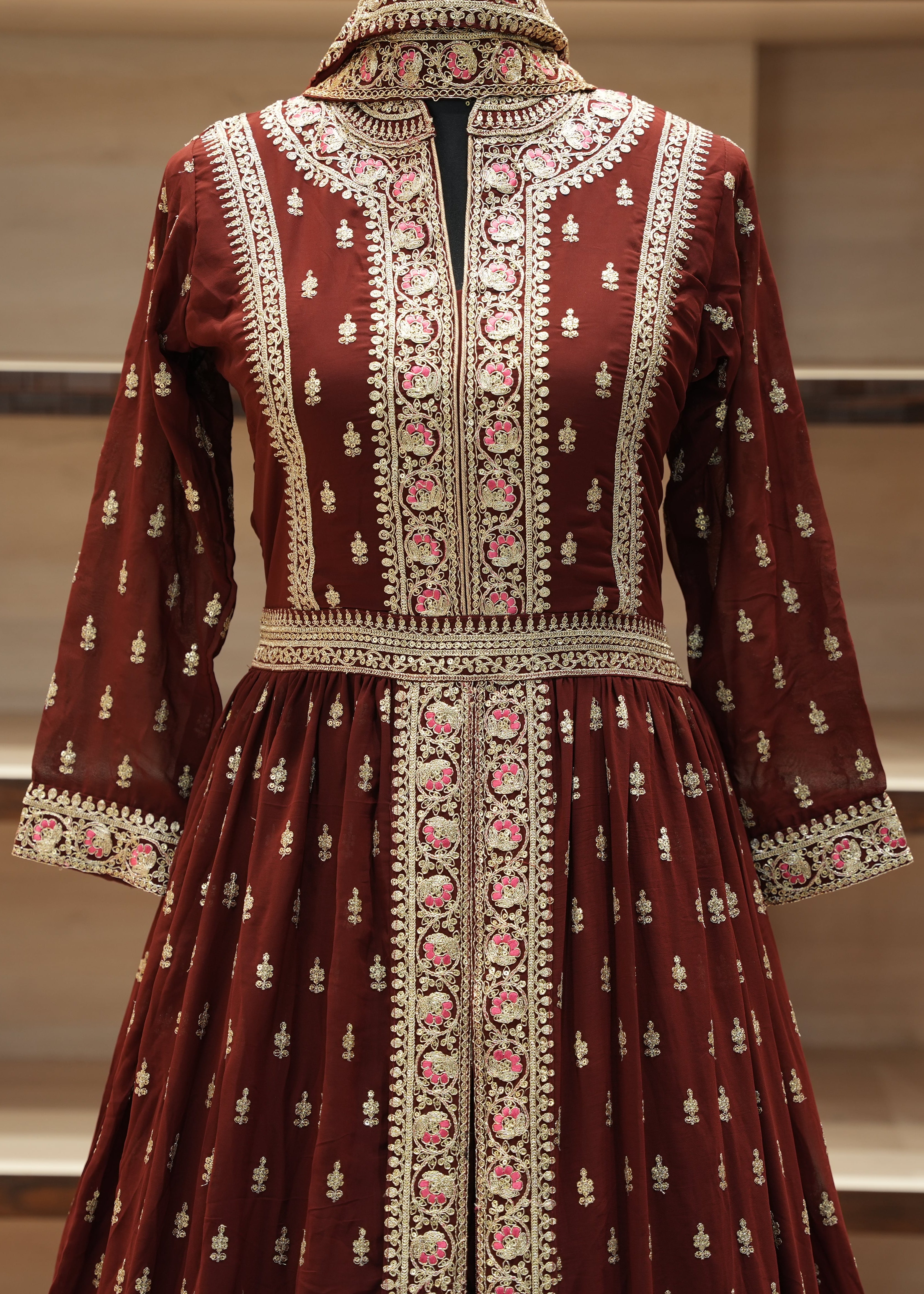 Maroon embroidered traditional dress on a mannequin against a neutral background